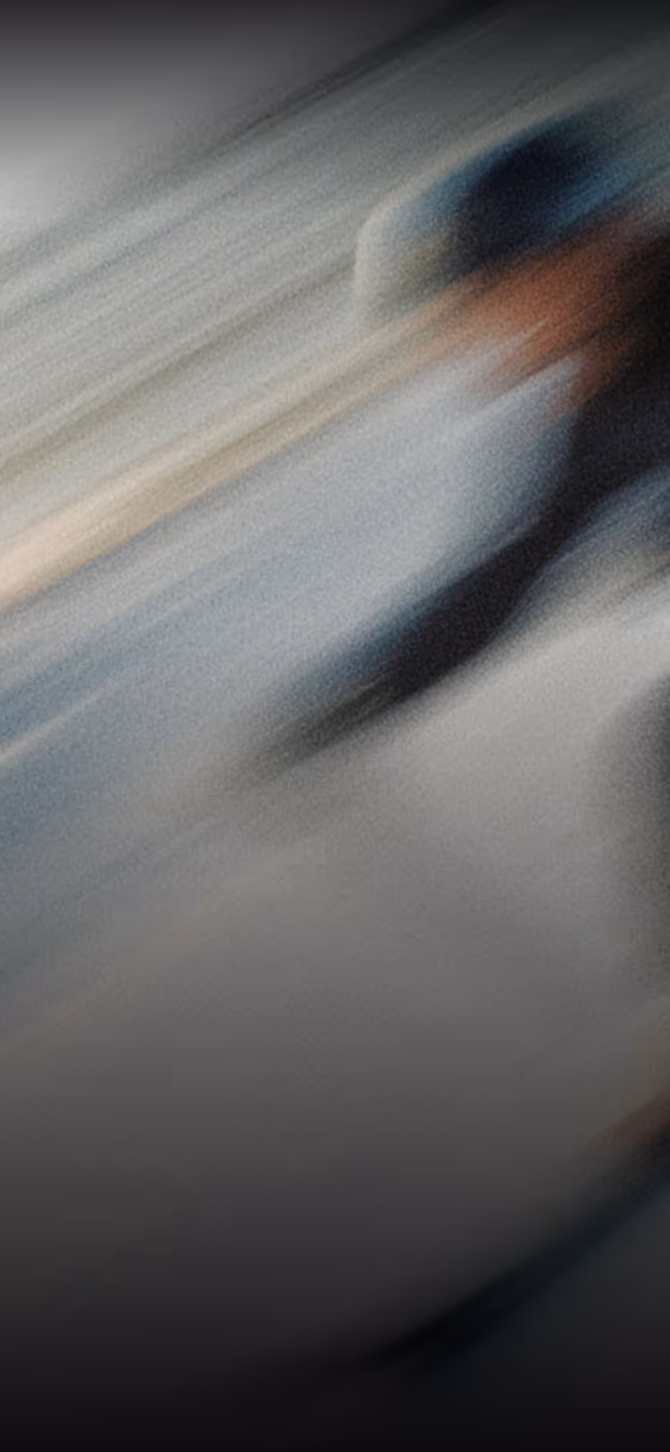 Abstract blurred image with streaks of blue, beige, and black colors blending diagonally.