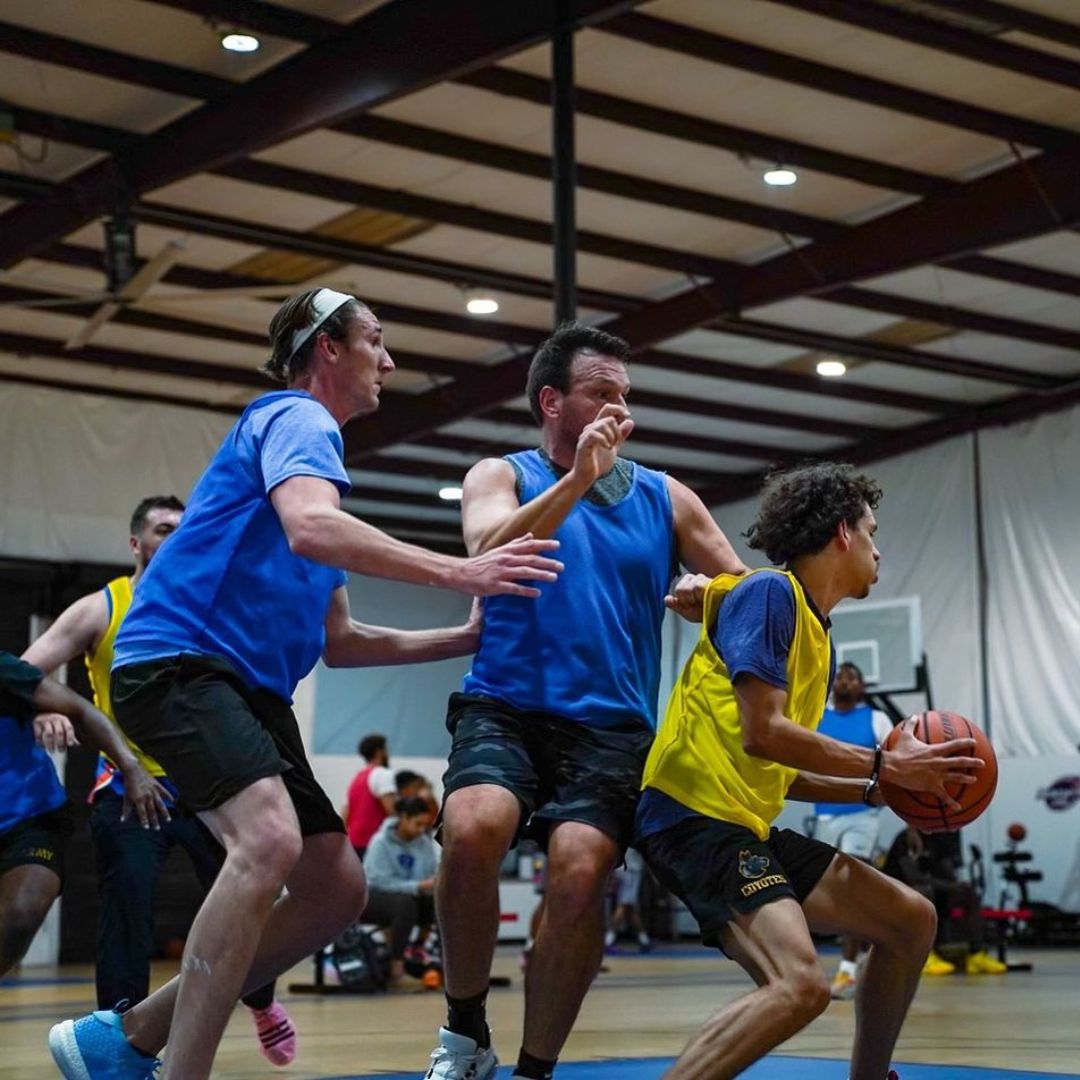 Adults playing basketball together