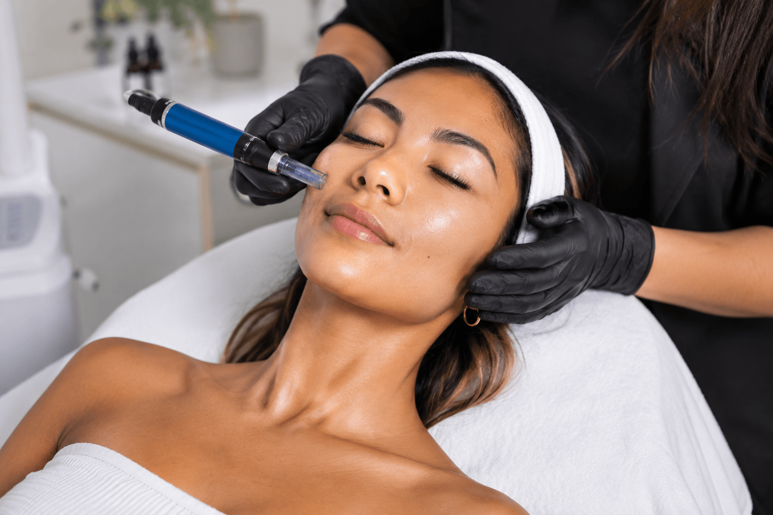 Client receiving SkinPen microneedling treatment to improve acne scars and skin texture in Honolulu, Hawaii clinic