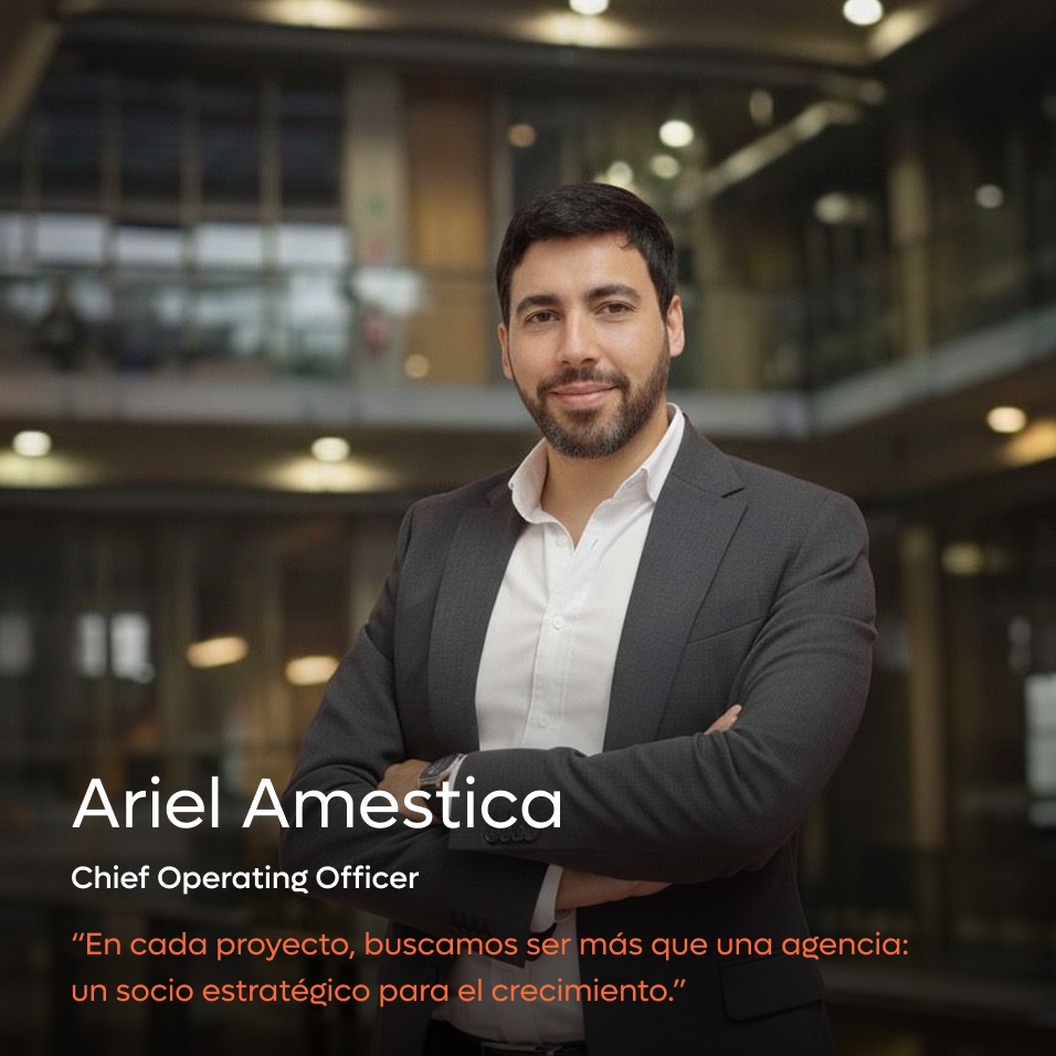 Confident man in a dark suit with arms crossed standing in a modern office background.