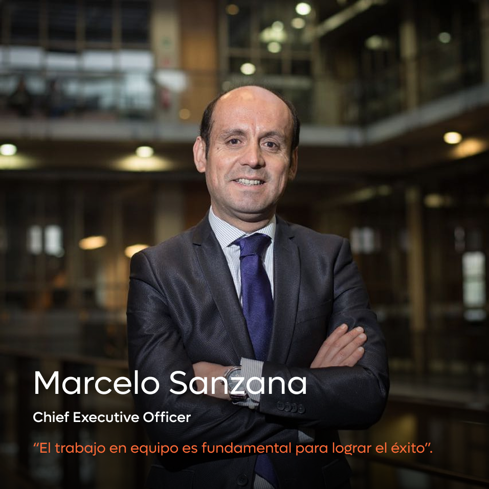 Portrait of Marcelo Sanzana in a suit with arms crossed, standing in an office environment.