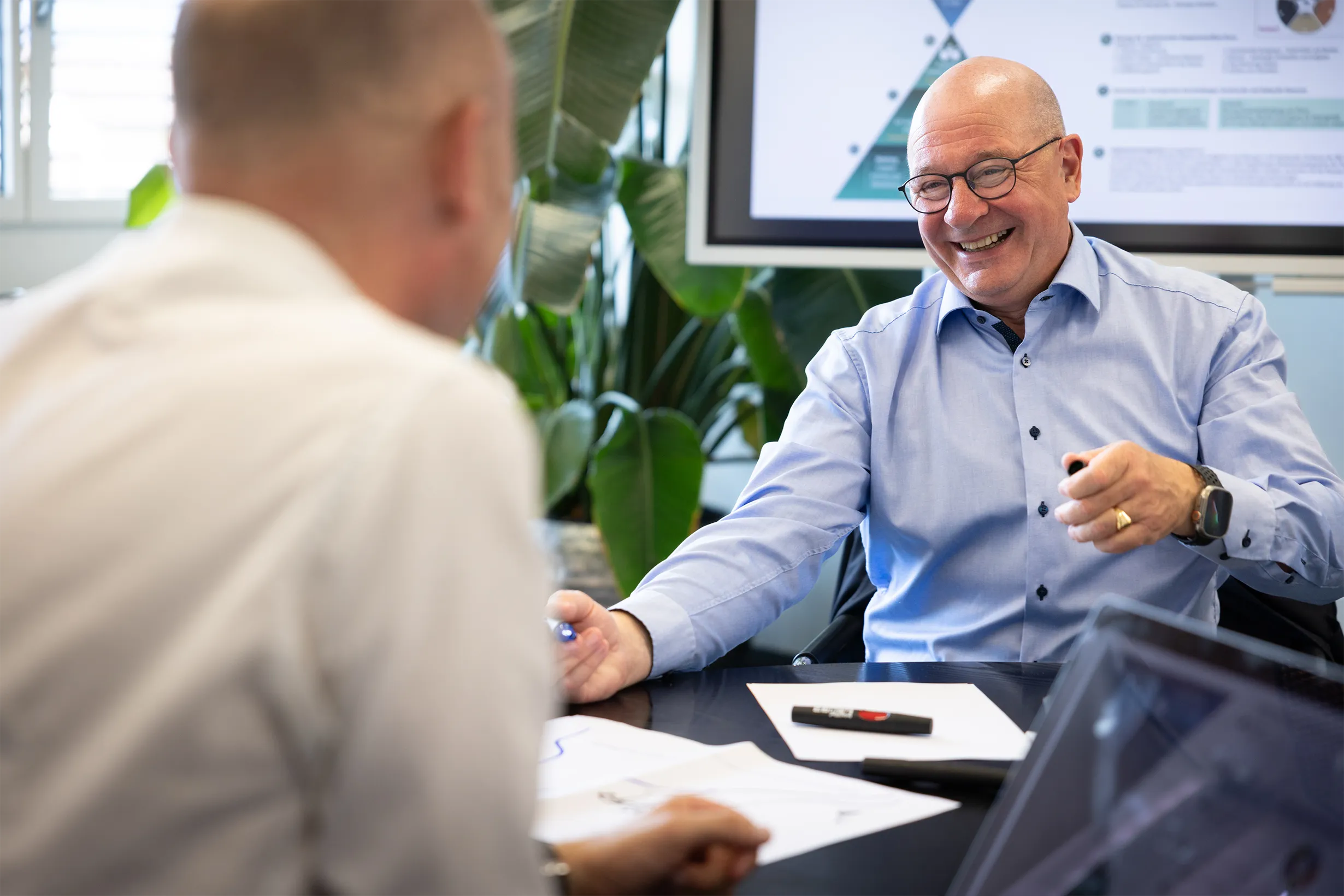 Martin sitzt lächelnd gegenüber einer anderen Person.