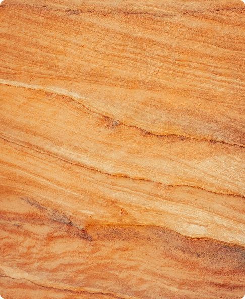 Close-up of orange and beige layered sandstone with natural textured patterns.
