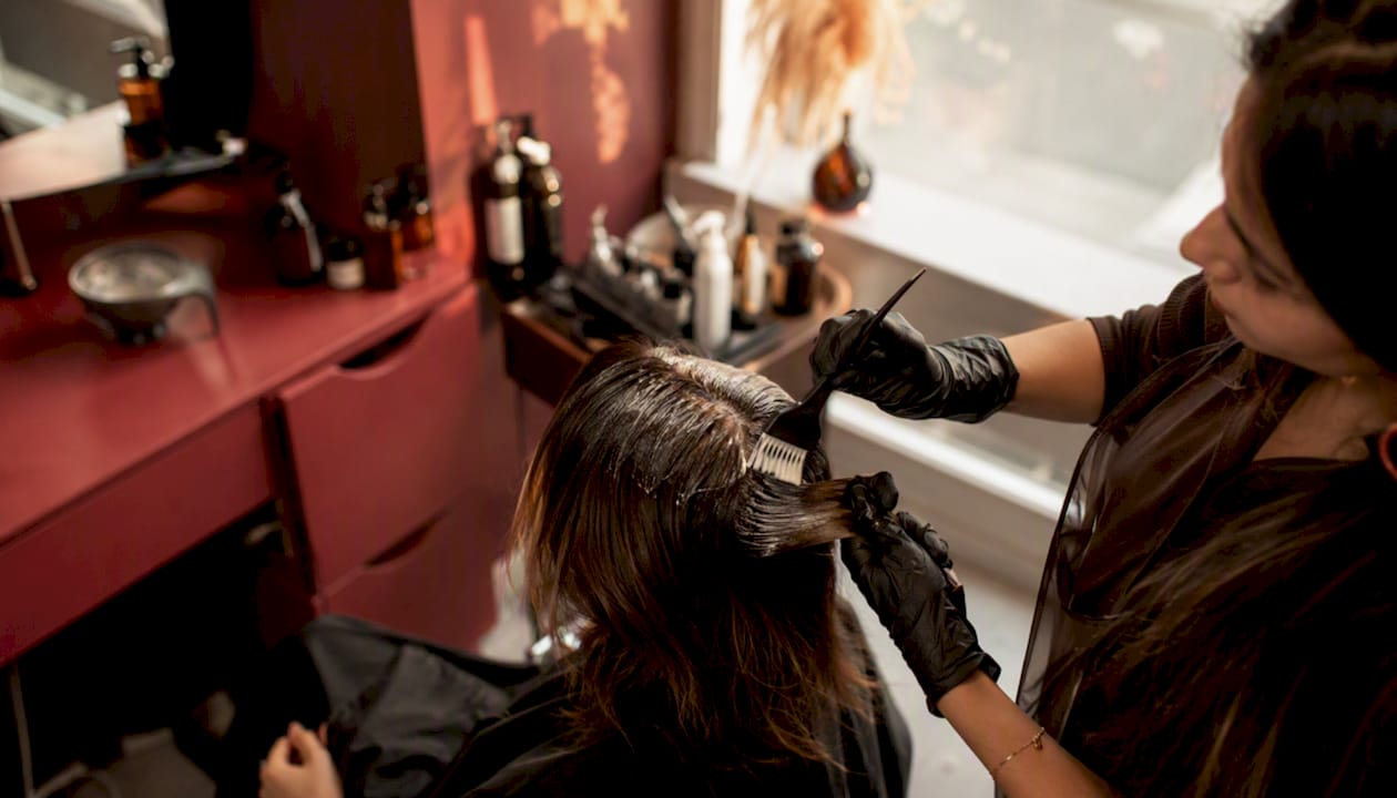 Hands applying hair treatment in salon