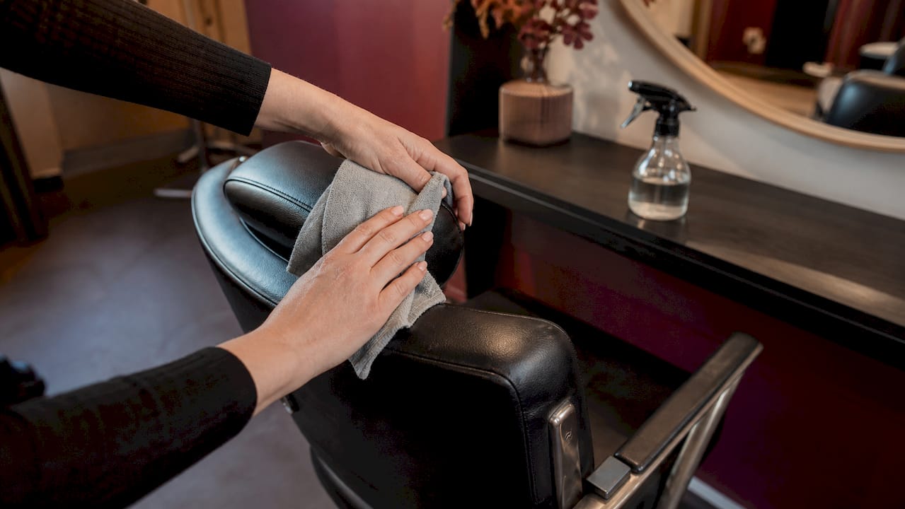 Hands maintaining salon styling chair
