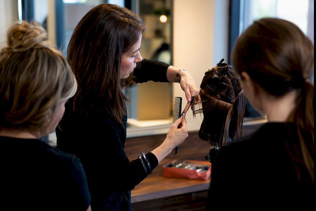 Stylist demonstrating technique to colleagues