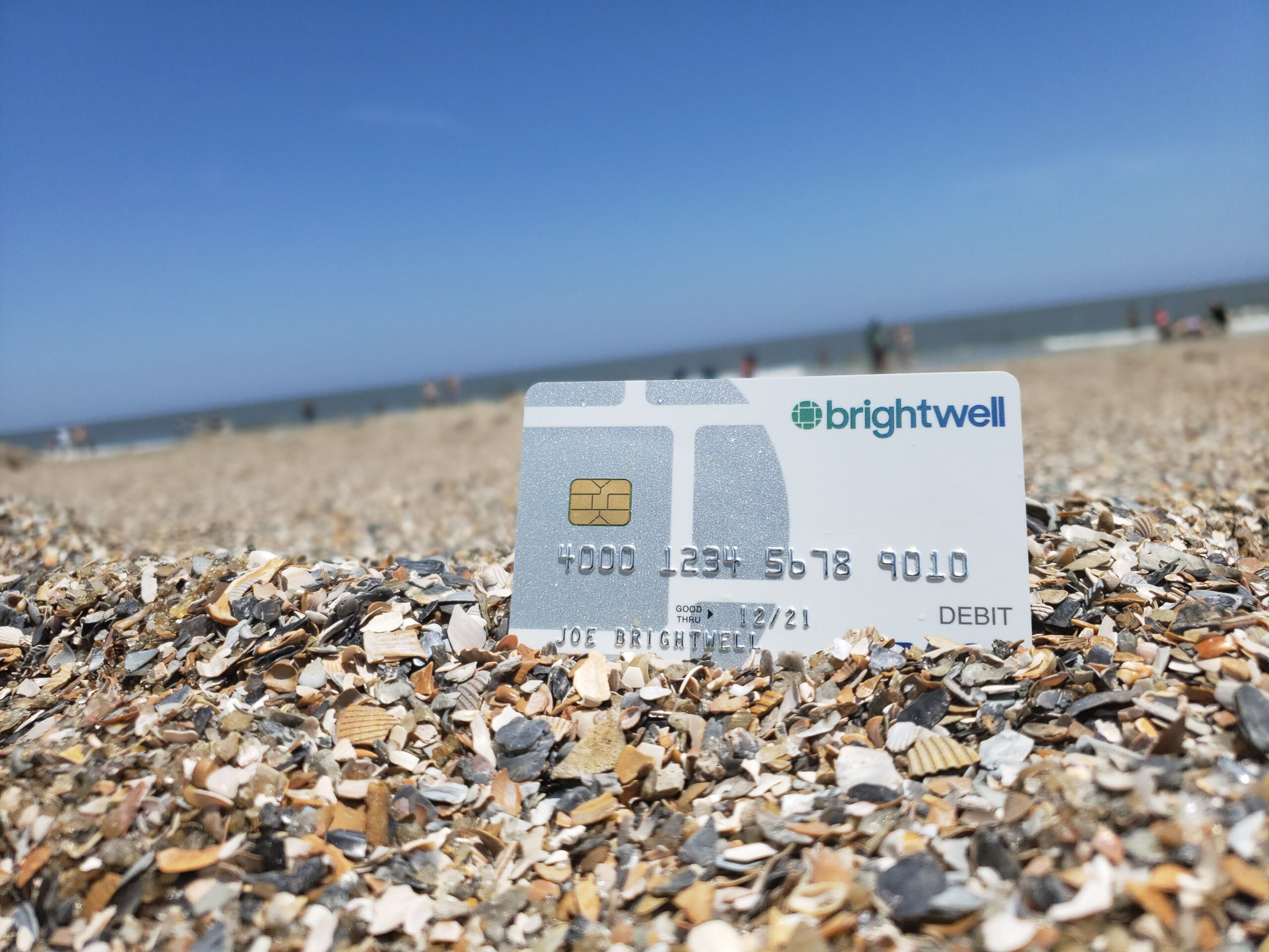 A white credit card sitting on top of a pile of rocks.