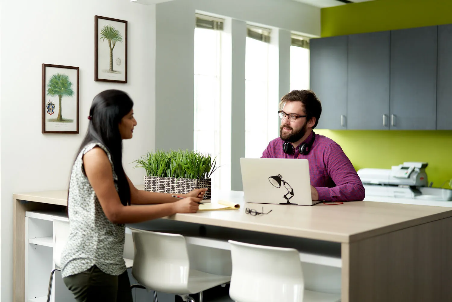 A man and a woman sitting at a table with a laptop.