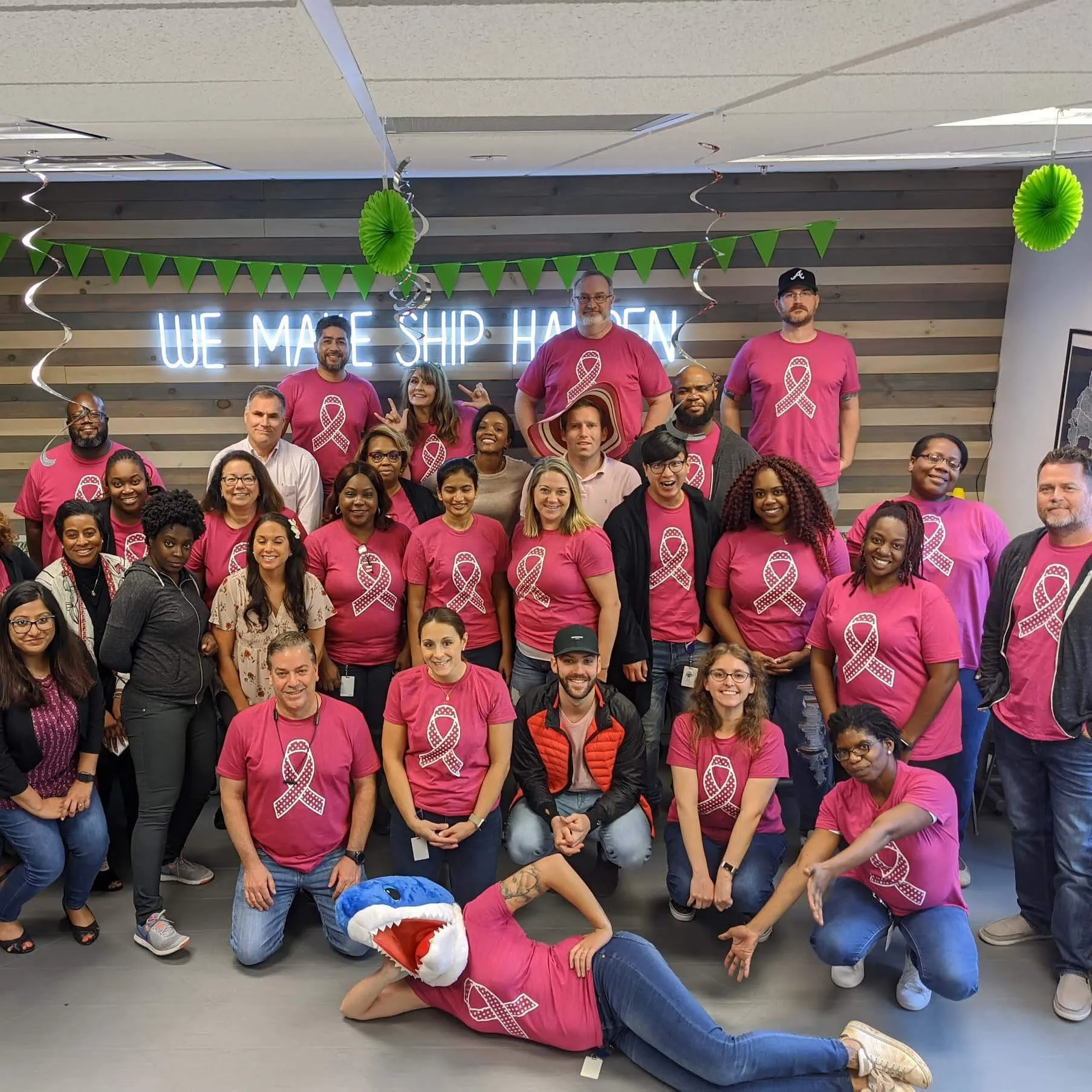 A group of people in pink shirts posing for a picture.