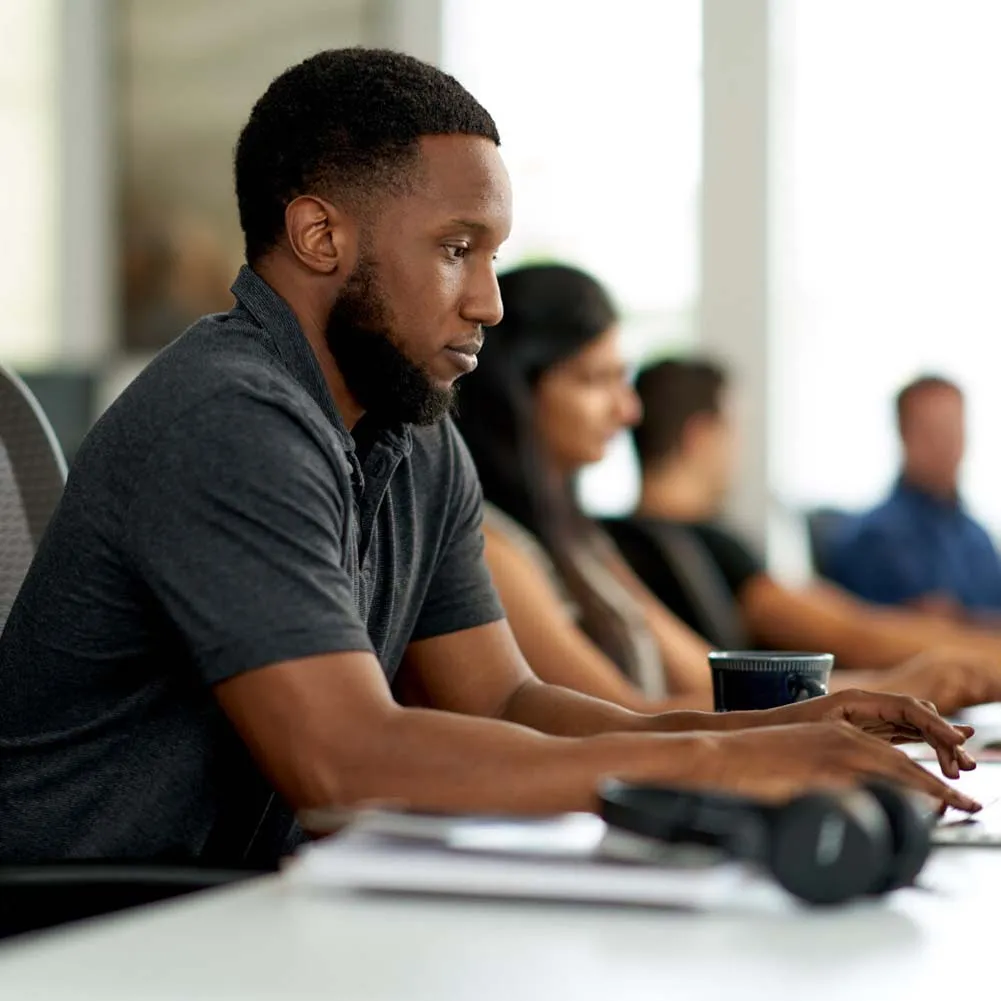 A man sitting in front of a laptop computer.