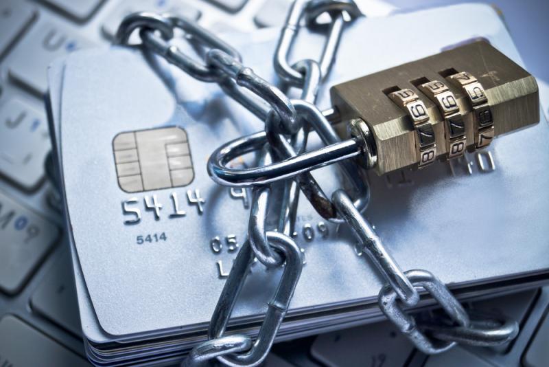 A stack of debit cards wrapped up in a locked chain, signifying protection from payment fraud. Brightwell is a payments technology company with products that enable both global remittances and fraud protection.