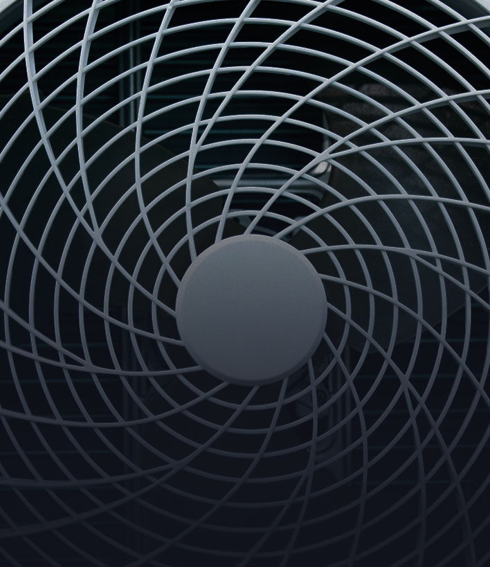 Close-up of a gray fan with spiral protective grill covering the blades.