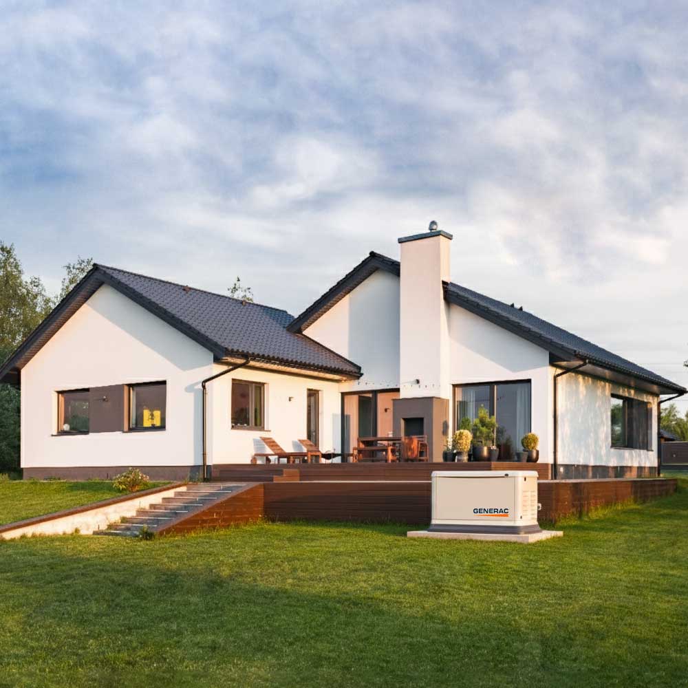 Modern white one-story house with dark roof, wooden deck, outdoor seating, and a Generac backup generator on the lawn.