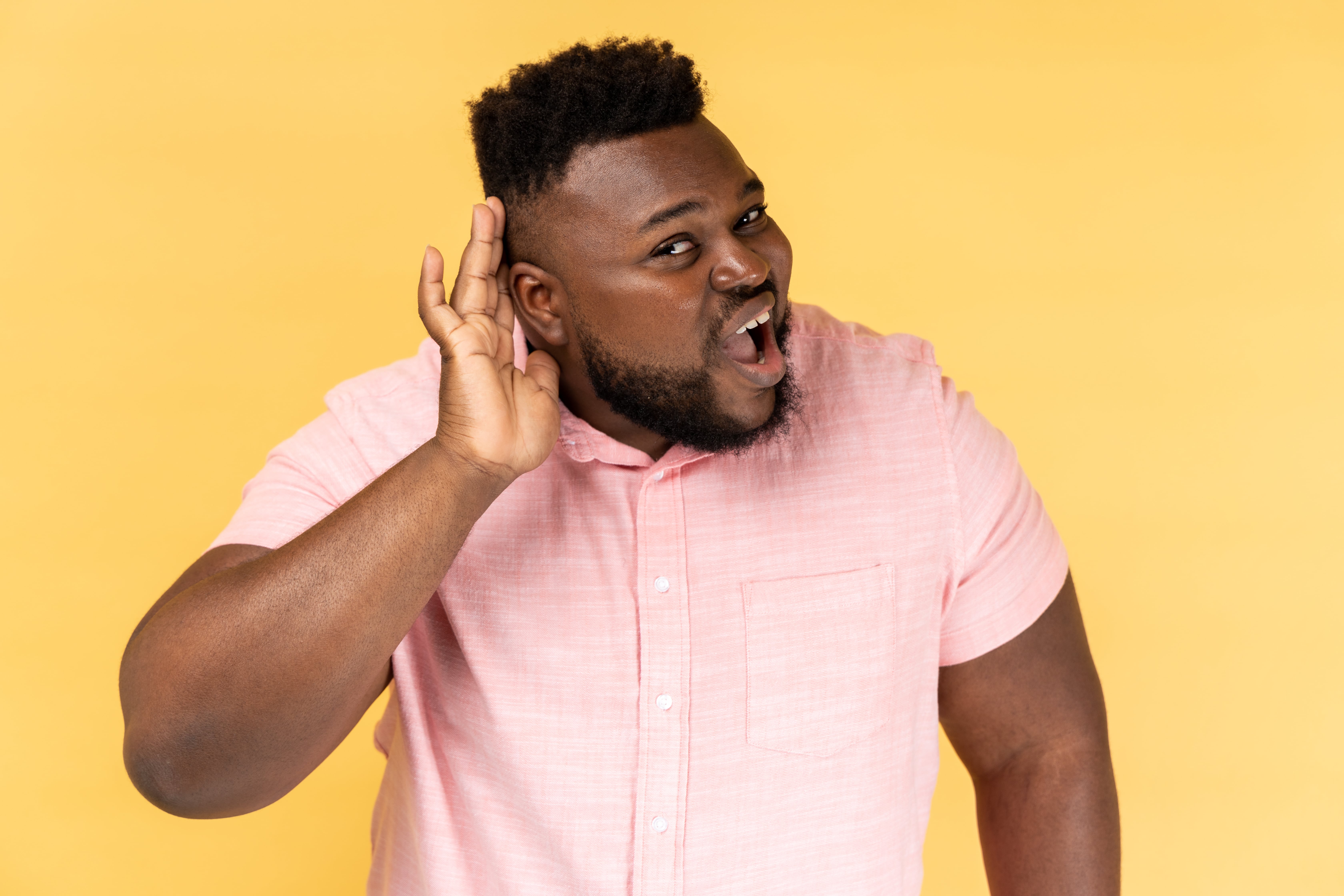 A man pointing to her ear