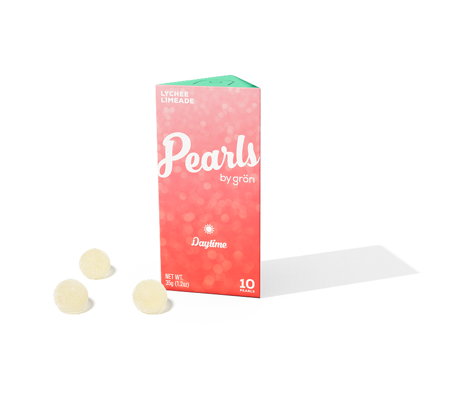 Pink and green box labeled Pearls by grön Lychee Limeade flavor with three round white Pearls beside it.
