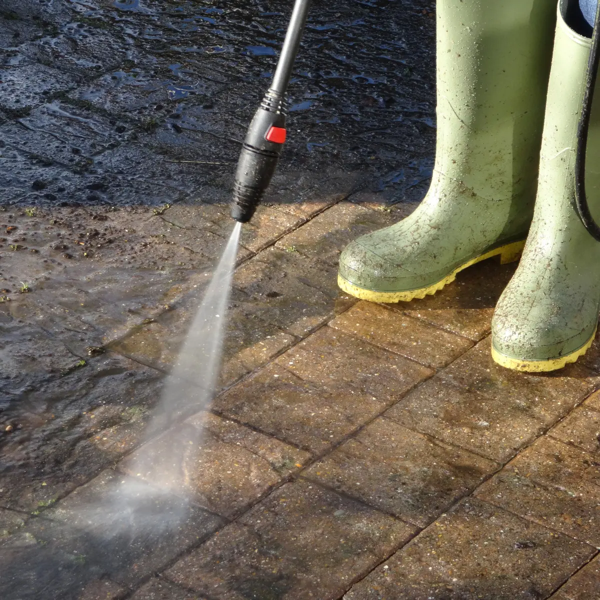 Electric floor cleaning machine scrubbing a wet tiled floor with soap suds around.