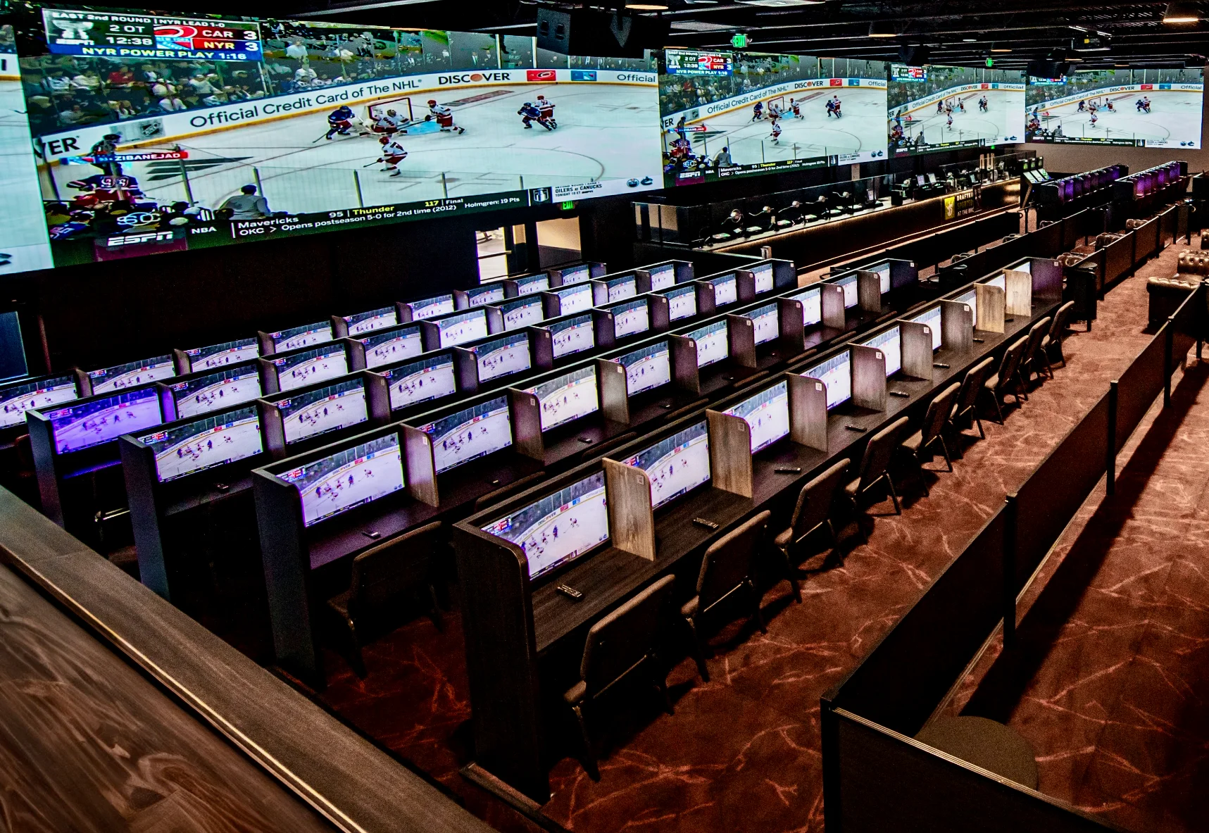 Large casino room with tvs. large tv wall in background