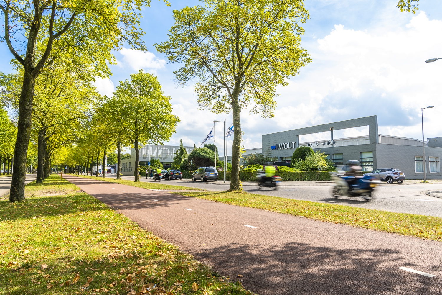 A close-up of a modern architectural staircase with curved railings and beige concrete, against a clear blue sky.