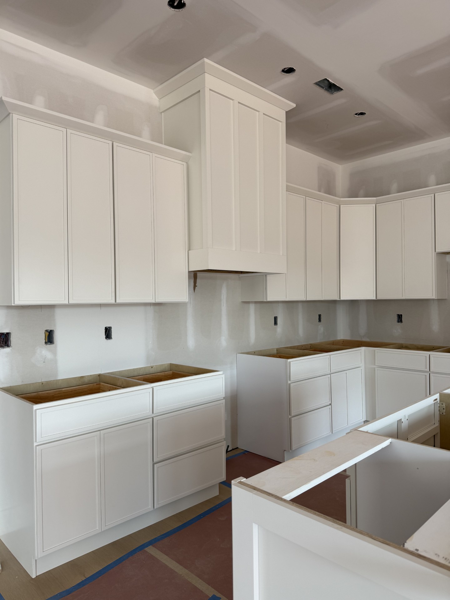 Laundry room with dark wood cabinets, white quartz countertop, light gray subway tile backsplash, and wood-look tile flooring.