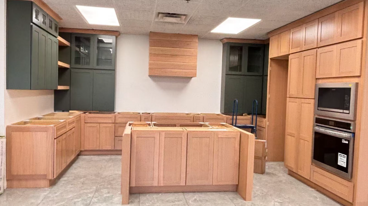 Modern kitchen corner with white cabinets and granite countertops, a double sink, and various kitchen items including a coffee maker and utensil holder.