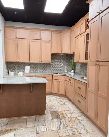 Modern kitchen with dark wood cabinets, white countertops, a large island with a gold faucet, stainless steel appliances, subway tile backsplash, and a gold chandelier with eight shades.