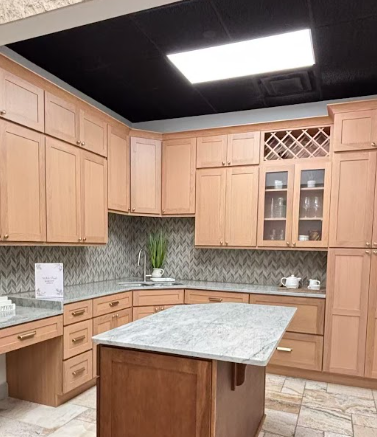 Modern kitchen with stainless steel refrigerator, dark wooden cabinets, marble countertops, and a colorful rug on tiled floor.