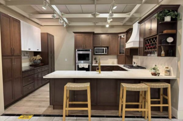 Laundry room with dark wood cabinets, white quartz countertop, light gray subway tile backsplash, and wood-look tile flooring.