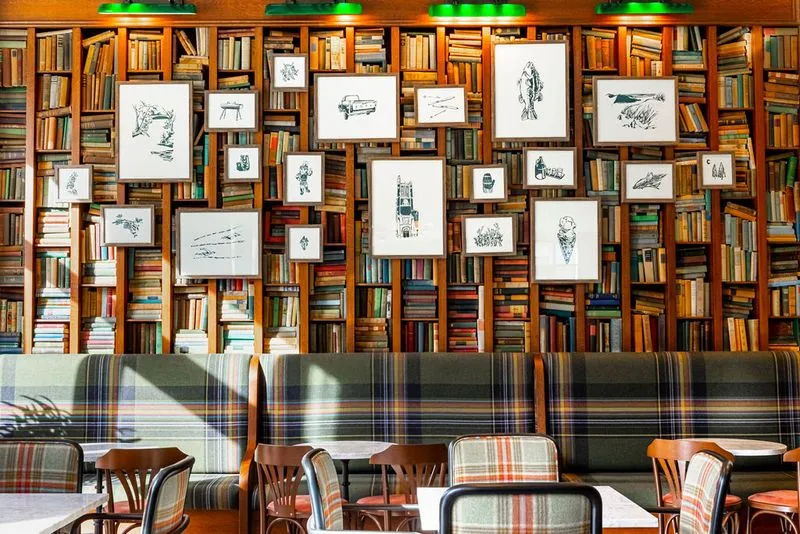 collection of framed prints on wall of books as an art installation