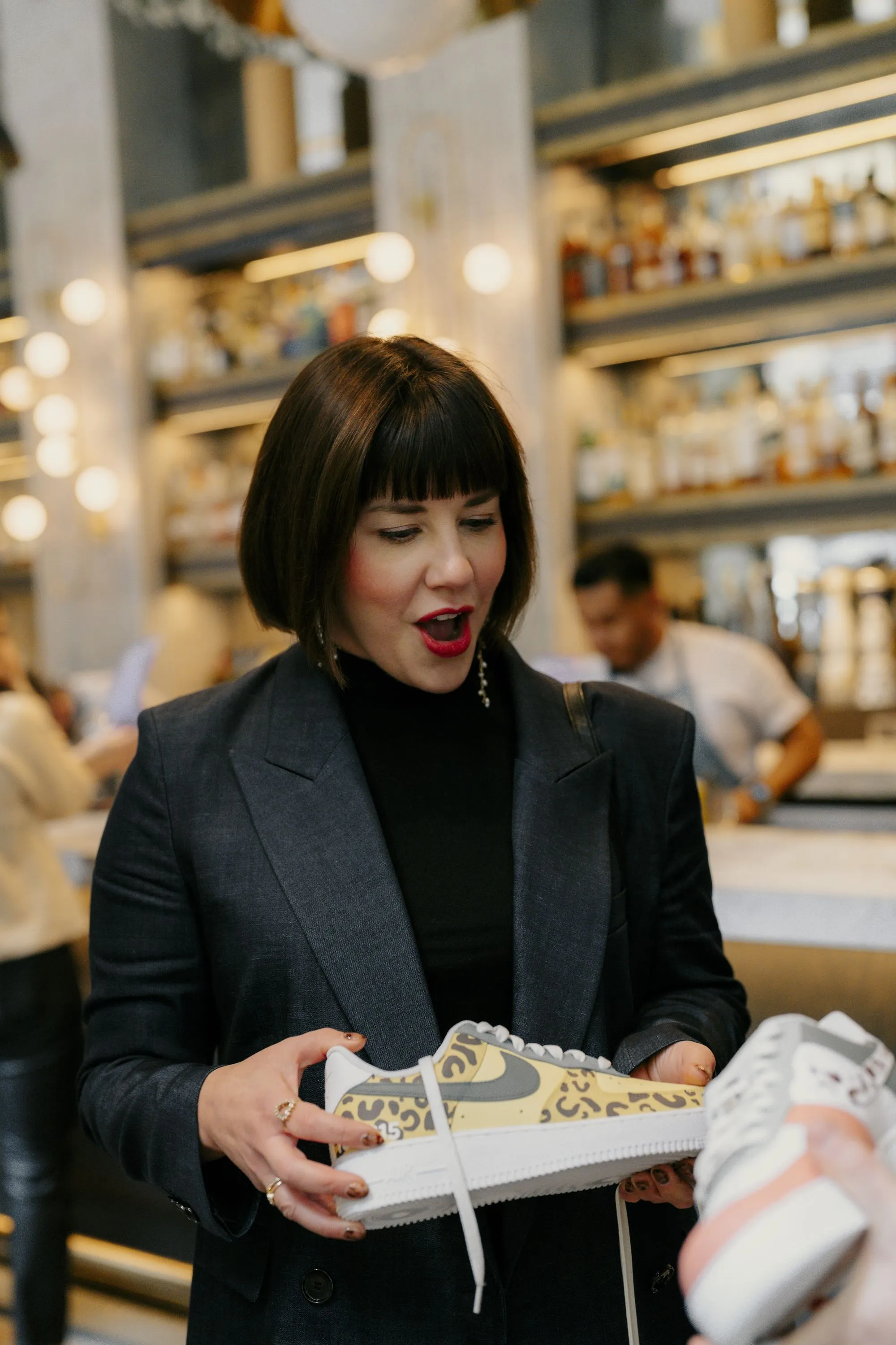 woman excitedly looking at custom painted sneaker
