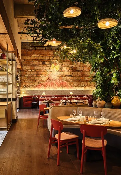 restaurant with mural of woman with pasta face on brick wall