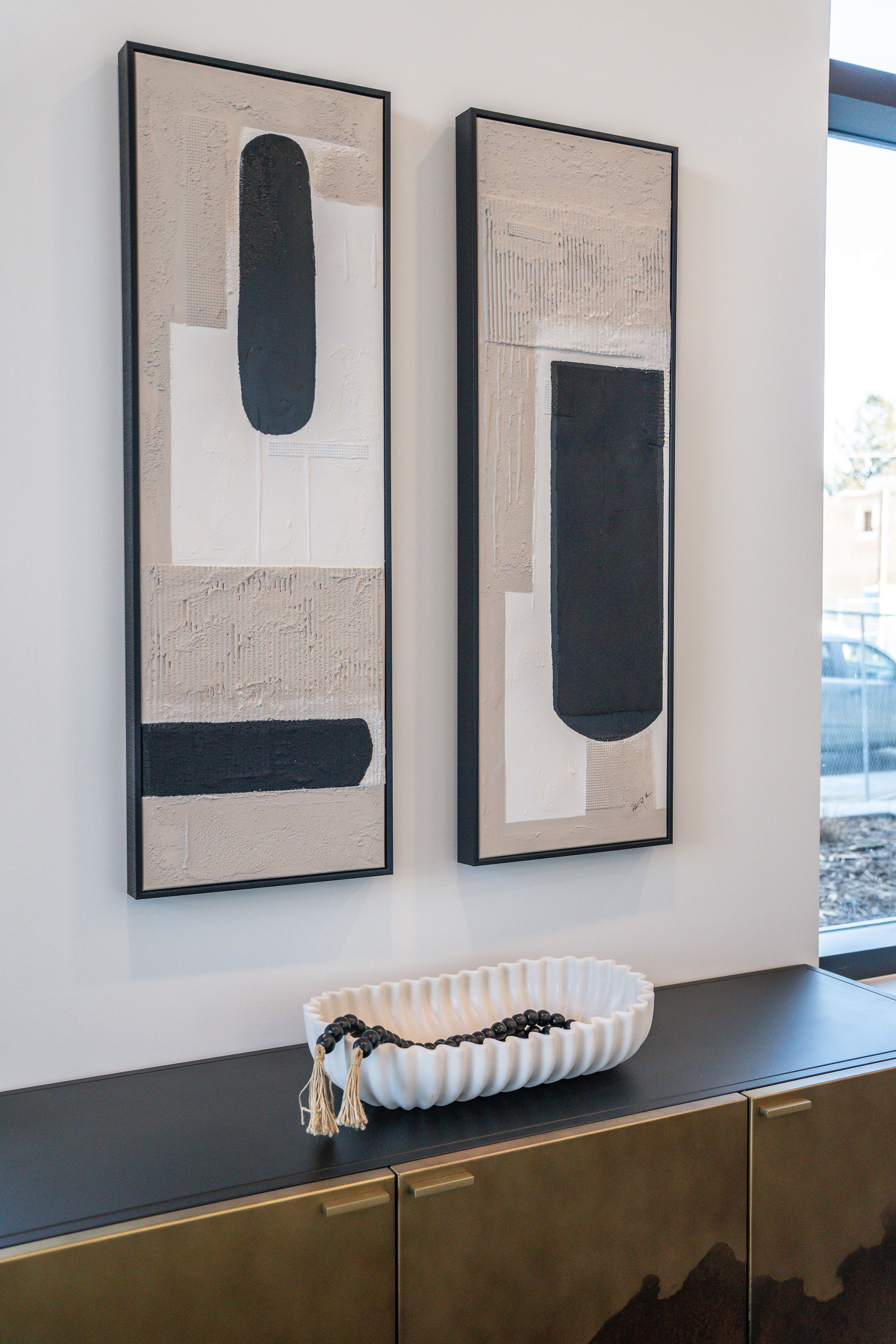 Modern game room amenity at Munro with a round marble table with decorative balls, dark cabinetry with a sink and chessboard, pool table, and floor-to-ceiling windows leading to a balcony.
