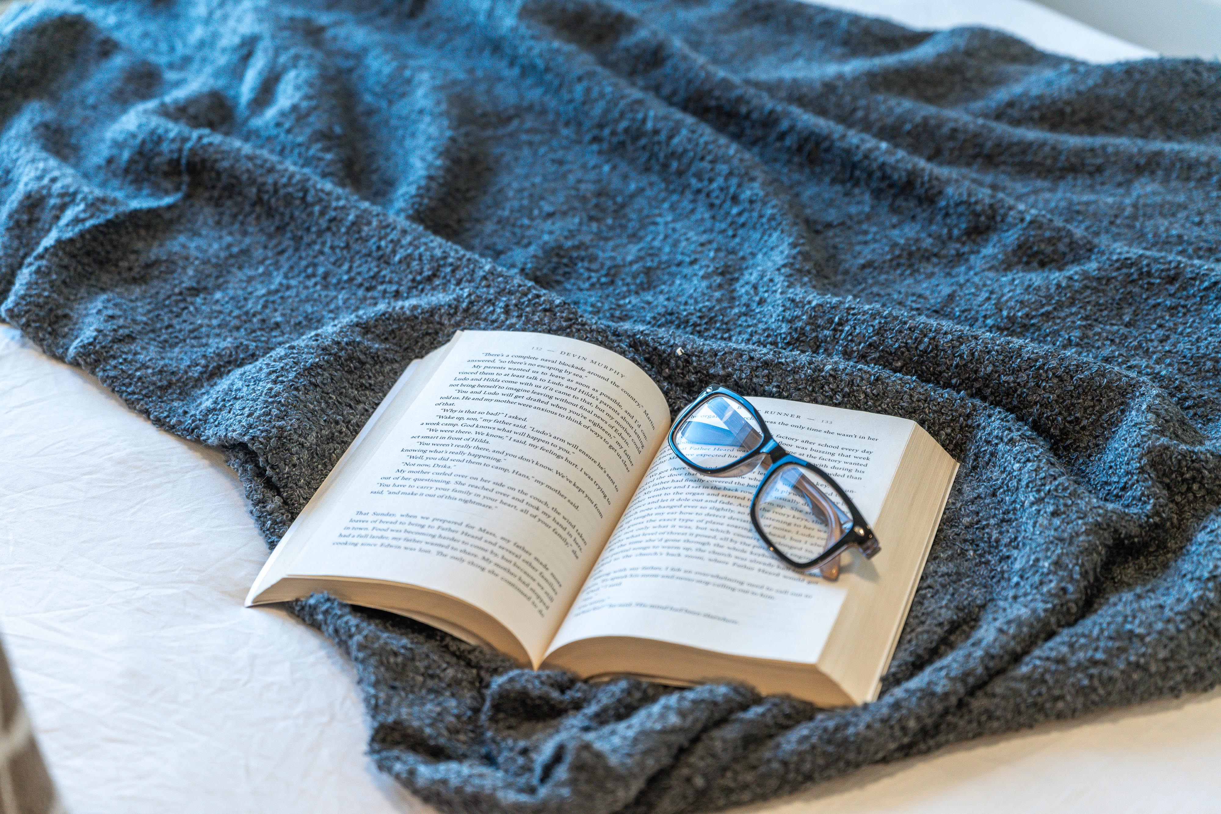 Munro's Modern kitchen with gray cabinets, stainless steel appliances, kitchen island with two white bar stools and table settings, and wooden flooring.