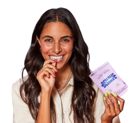 Smiling woman with long dark hair holding a package labeled 'Divine Lime' and about to eat a strip.