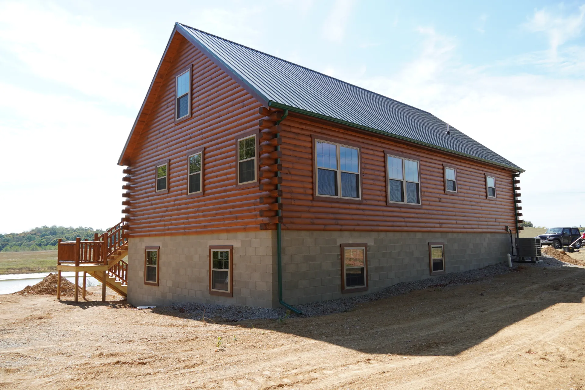 Two-story modular log cabin home built by Ohio log cabin builders featuring Amish craftsmanship, log-style exterior, metal roof, and custom cabin design.