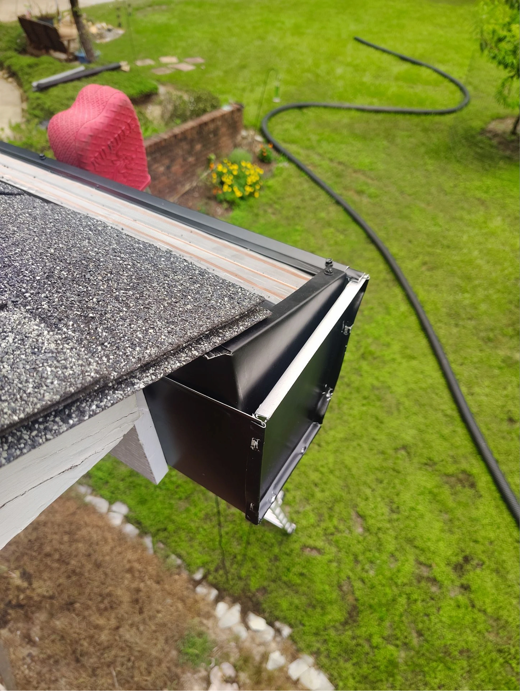 Close-up of newly installed black aluminum gutter corner on a residential roof in Raleigh, North Carolina.