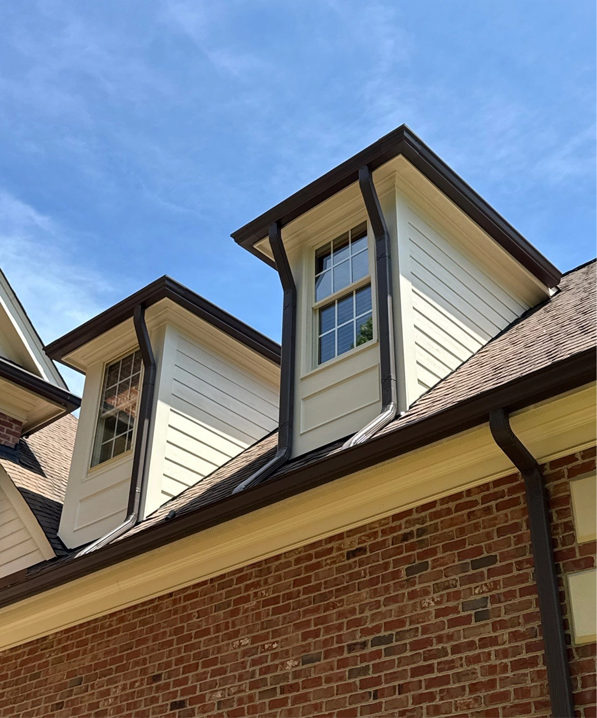 Finished showcase of gutter and downspout system installed along a residential home exterior for effective water drainage.