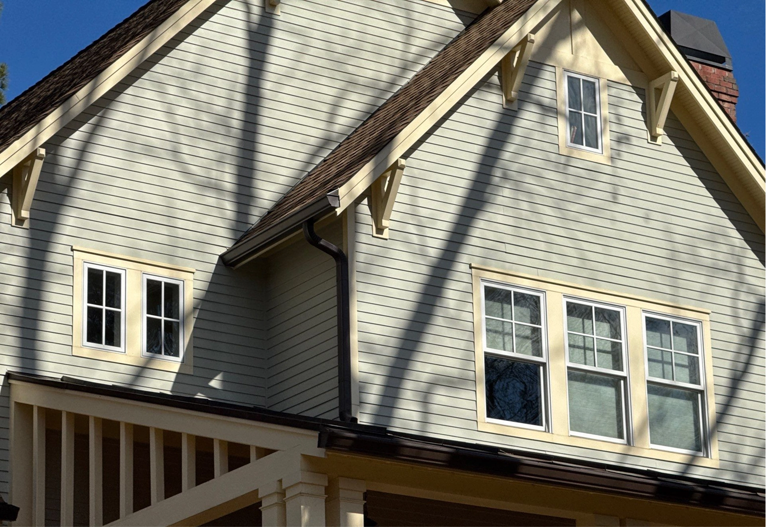 Residential home exterior with professionally installed gutters and downspouts designed to manage rainwater and protect the home.