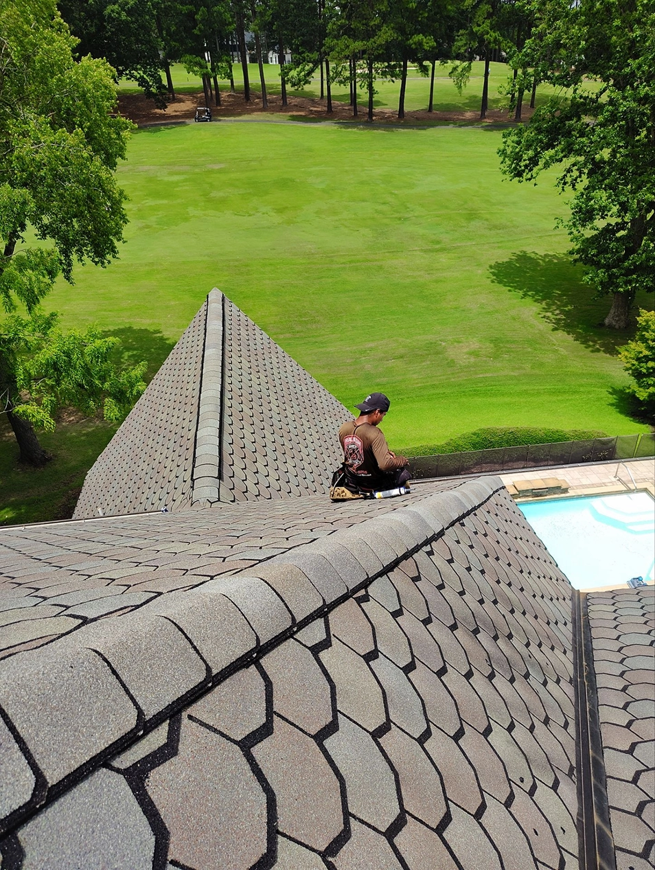 Completed residential roofing work with a technician finishing details along the roofline for durable protection and a clean appearance.