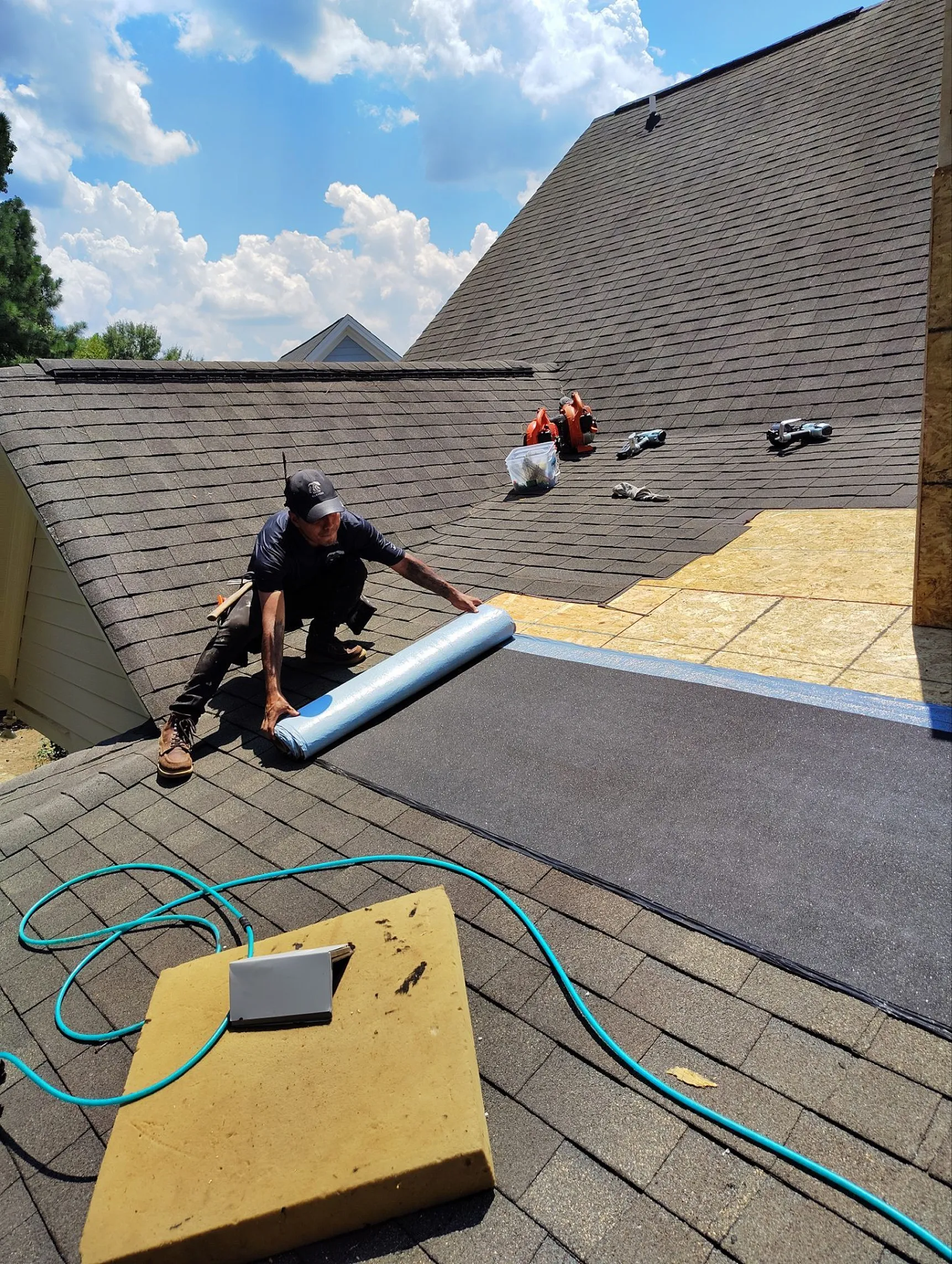Professional roofing work in progress as a technician installs protective roofing materials to ensure durability and long-term performance.