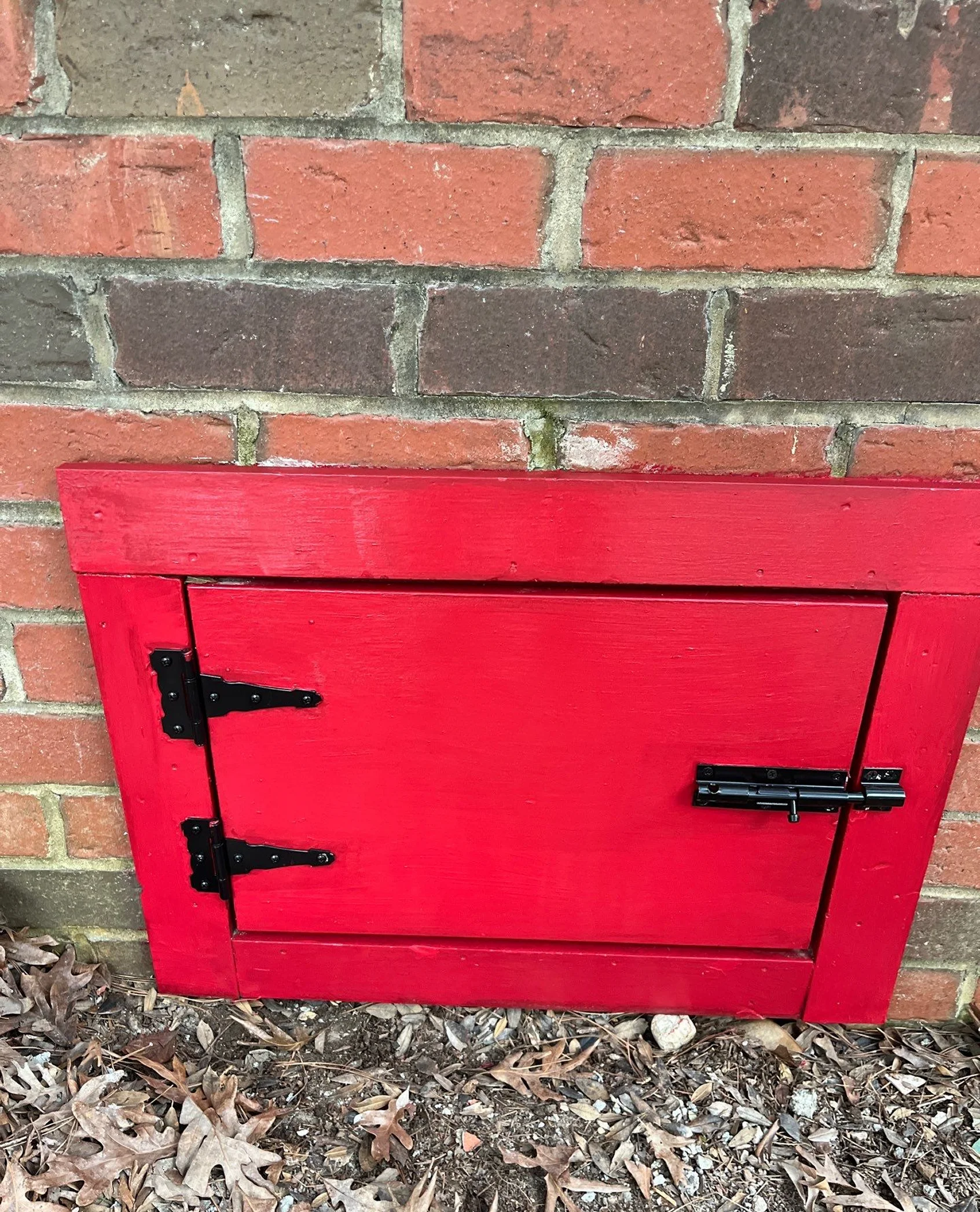 Refurbished red exterior access door with updated hardware.