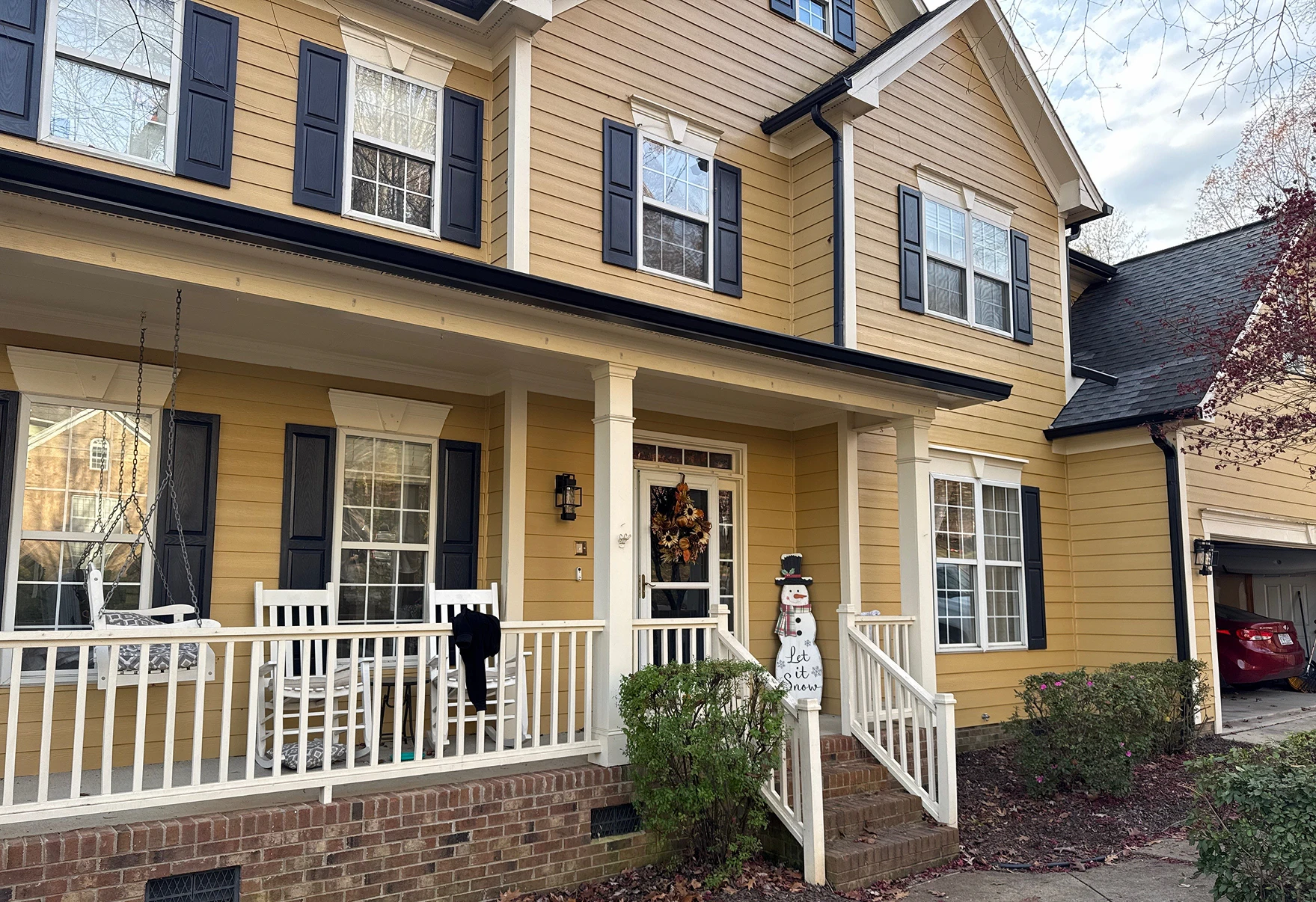 Residential exterior featuring updated gutters, downspouts, and window shutters.