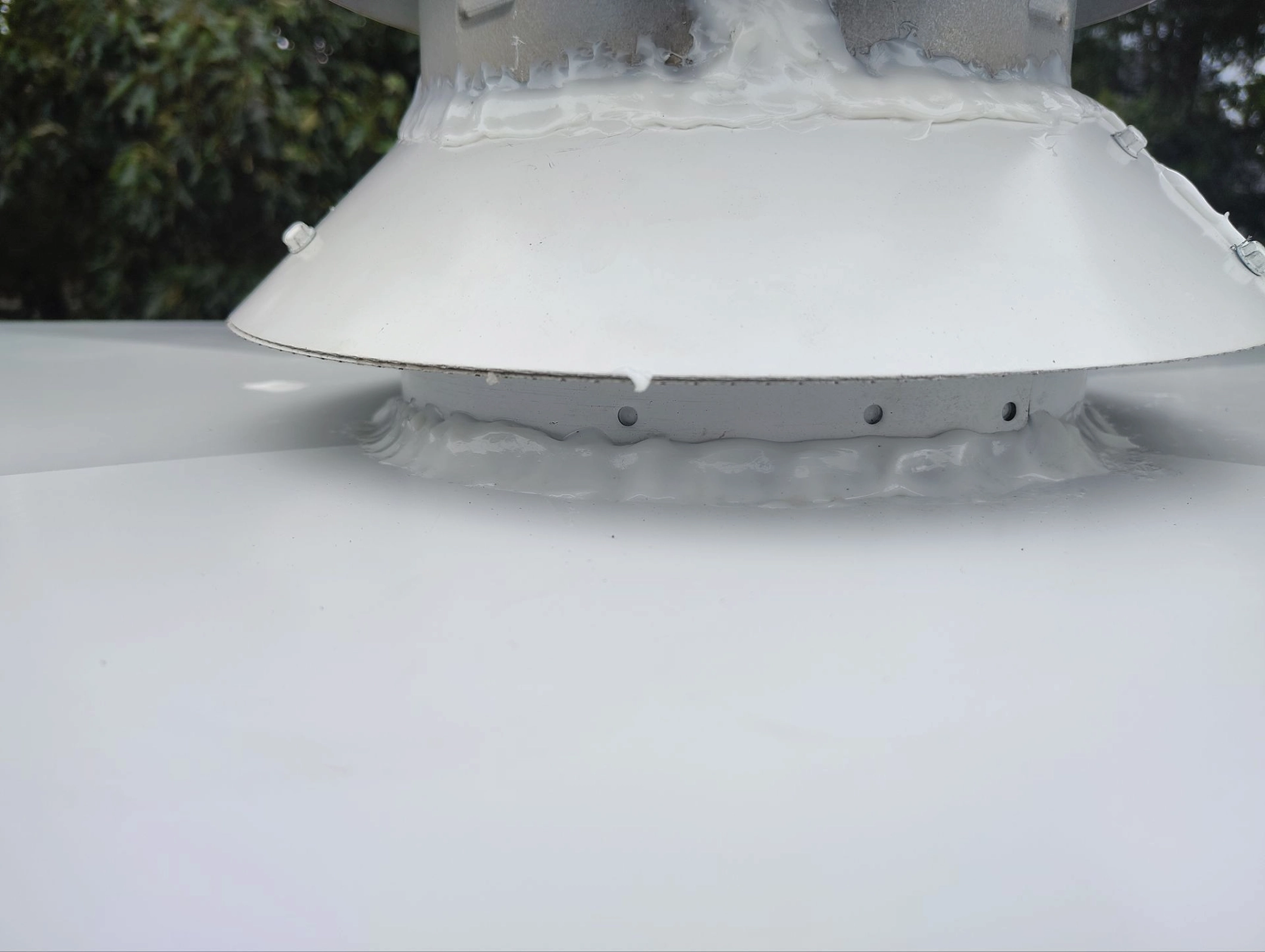 Detail view of chimney cap base with properly sealed flashing to prevent water intrusion.