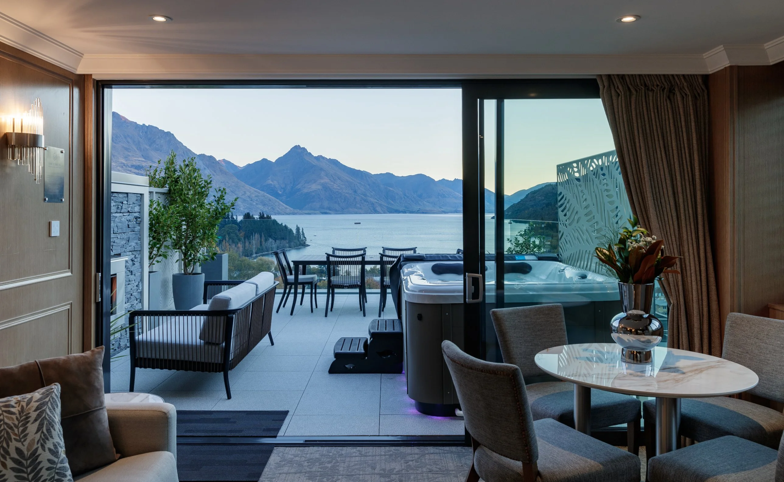 Lakeview Suite lounge opening onto a terrace with spa pool overlooking Lake Wakatipu
