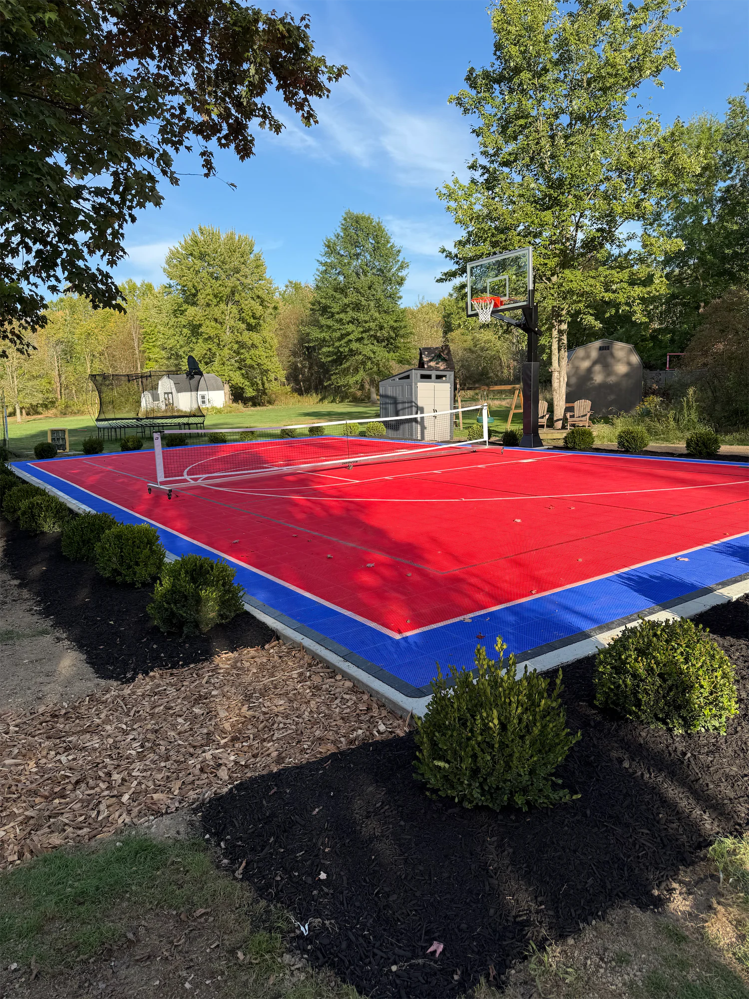 Outdoor basketball court surrounded by trees