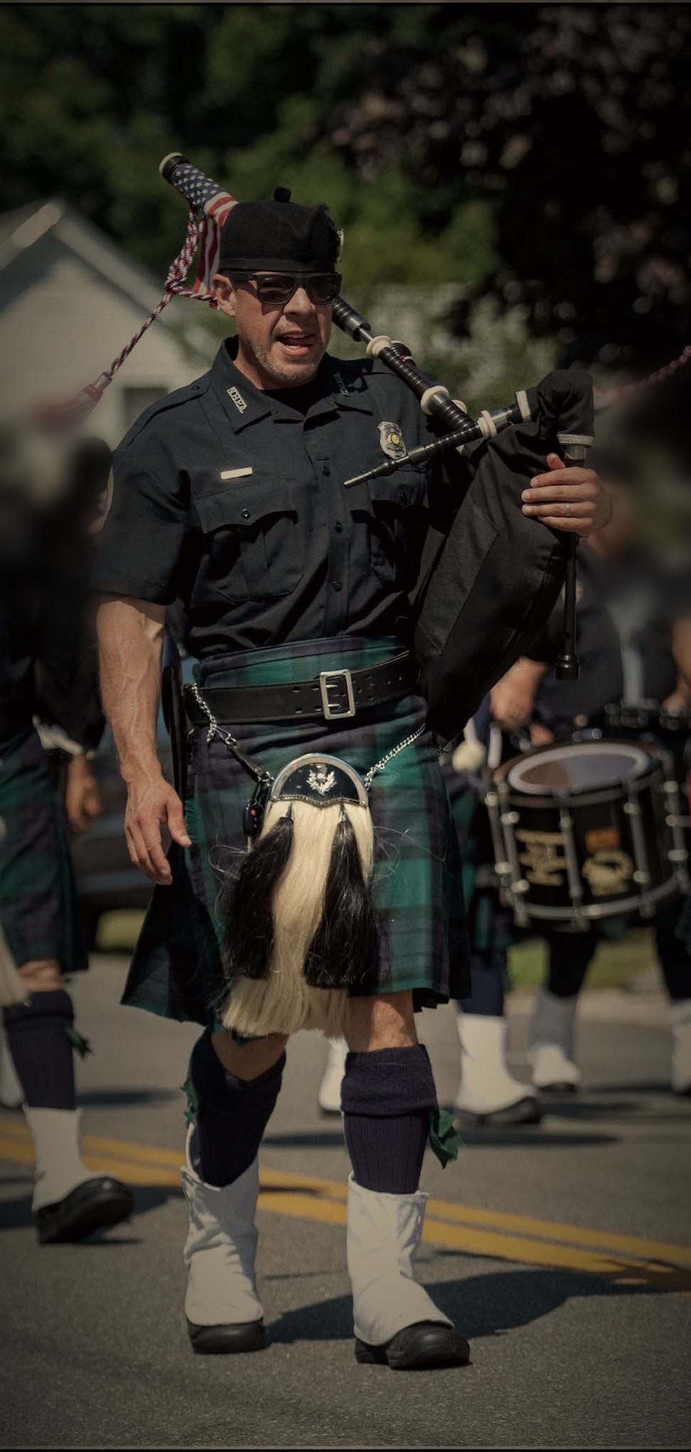 Steve in full Highland dress playing the bagpipes on parade