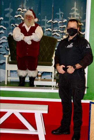 Uniformed Blackbird security guard with Santa Claus in background