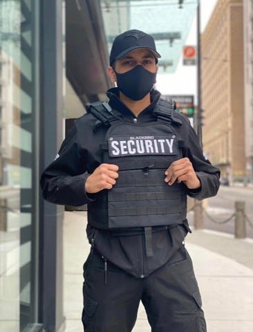 Uniformed Blackbird security guards standing in front of building