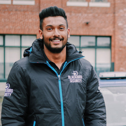 Male Blackbird security guard in branded jacket
