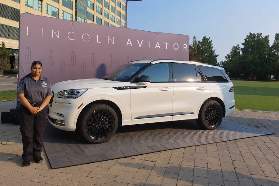 A Blackbird Security guard poses beside a white Lincoln SUV at a high-end event in Toronto.