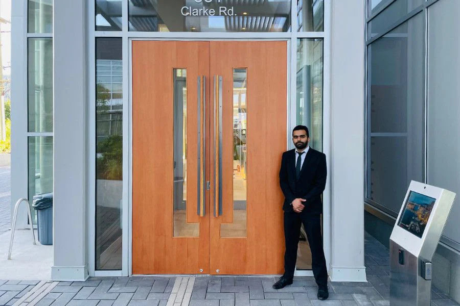 A Blackbird Security guard stands outside large double condominium doors.